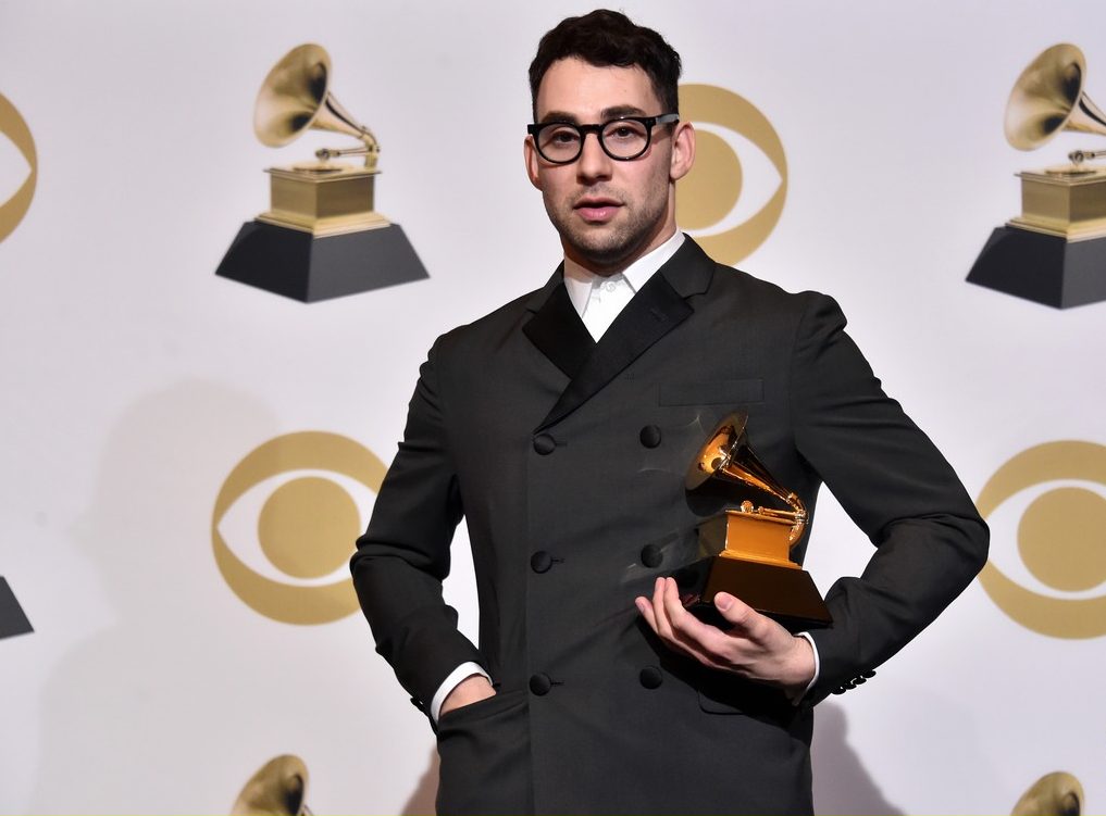 Jack Antonoff wearing a black coat while holding a Grammy